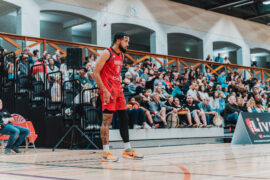 basketball player standing with crowds at the background