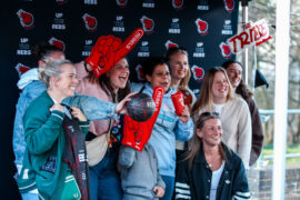 GROUP OF PEOPLE POSING IN FRONT OF REBELS BACKGROUND