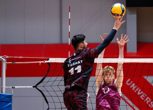 Men's Volleyball players hitting ball