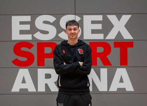 Smiling Essex Sport Staff member in the Essex Sport Arena - text in background 'ESSEX SPORT ARENA'